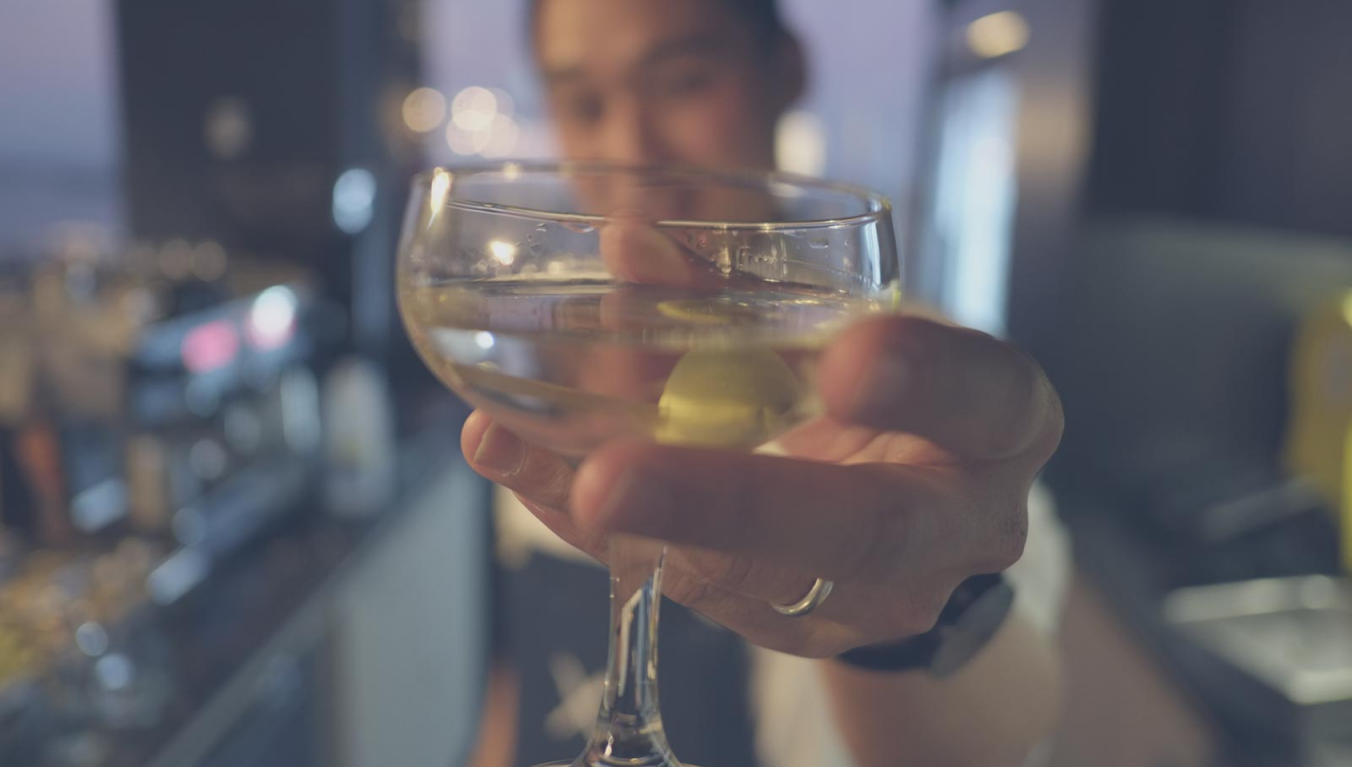 A photo of me, smiling, holding a cocktail